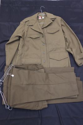 une photo d'un costume et d'un pantalon posés sur un lit