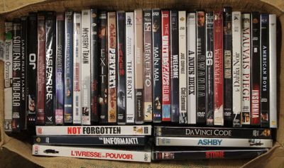 un grand nombre de DVD dans une boîte en carton posée sur le sol