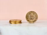 two gold coins sitting on top of a marble counter top