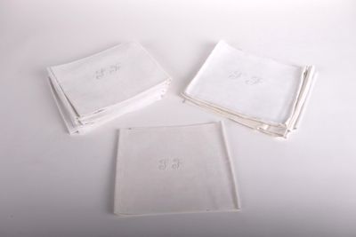 Trois serviettes blanches sont posées sur une table blanche.