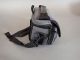 a camera bag with a strap on it on a table