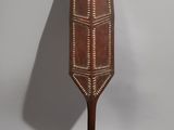 an old wooden paddle with a decorative design on it