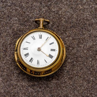 une montre de poche en or avec des chiffres romains