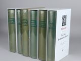 four books in a row sitting on top of a white box