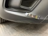 a sticker on the bumper of a car that is parked on the street