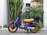 a blue and orange scooter parked in front of a building