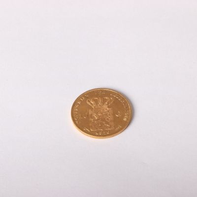 une pièce d'or sur une surface blanche avec un fond blanc