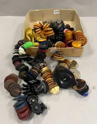 une boîte de boutons assortis posée sur une table