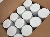 a box full of white candles sitting on a table