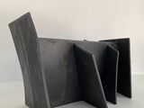 une image représentant une chaise noire posée sur un sol blanc