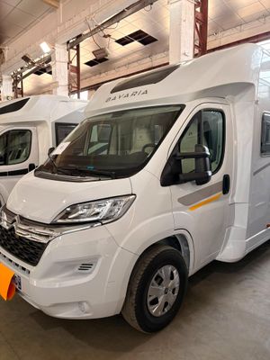 deux camping-cars blancs garés dans un garage, avec une étiquette jaune à l'avant