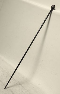 un long bâton appuyé contre un mur