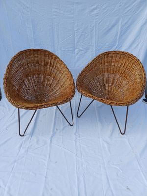 pair of wicker chairs with metal legs on a white background