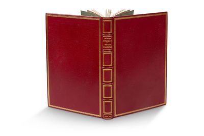 un livre rouge ouvert posé sur une table près d'un mur blanc