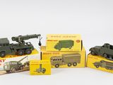 Plusieurs véhicules militaires miniatures sont posés sur des boîtes, sur une surface blanche.