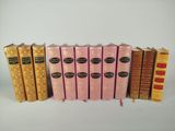 plusieurs livres sont alignés sur une surface blanche