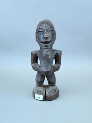 statue d'un homme tenant un bol, posée sur une surface blanche
