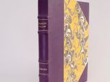 a purple book with a yellow cover on a white surface