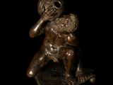 bronze statue of a man holding a baby on a black background