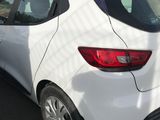 the rear end of a white car parked on the side of the road
