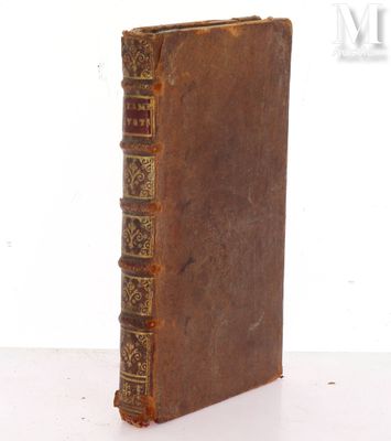 an old book sitting on top of a table next to a white wall