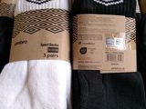 three pairs of black and white socks are in a cardboard box