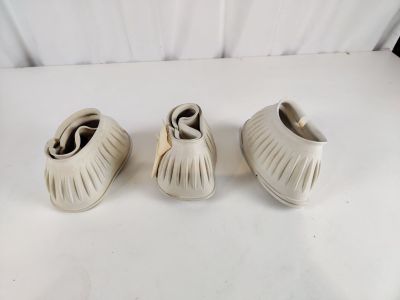 trois paires de chaussures blanches posées sur une table blanche