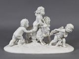 a figurine of a group of children playing with a goat