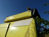 a yellow combiner that is sitting in the grass