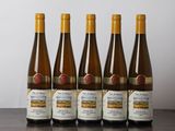 six bottles of wine are lined up on a wooden table