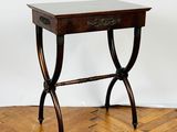 a small table with a drawer on it on a parquet floor