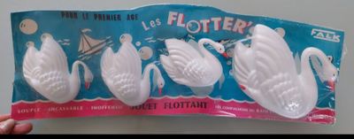 someone is holding a packet of plastic swans in front of a white wall