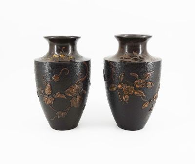two vases that are sitting side by side on a white surface