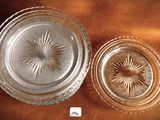 two glass dishes sitting on a brown table cloth