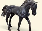 un cheval noir qui se tient debout sur une surface blanche