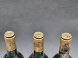 three bottles of wine sitting next to each other on top of a table