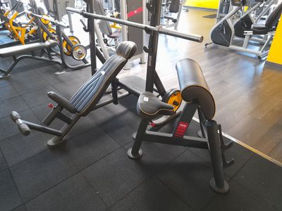 une salle de sport équipée d'un banc, d'haltères et d'autres appareils