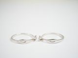 a pair of silver rings sitting on top of a white surface