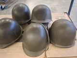 four helmets are sitting on a cardboard box in a warehouse