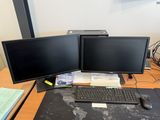 deux écrans d'ordinateur et un clavier sur un bureau