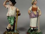 paire de figurines en céramique représentant un homme et une femme, l'un tenant une canne