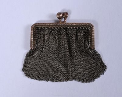 une image représentant un sac à main entouré d'une chaîne, posé sur une surface blanche