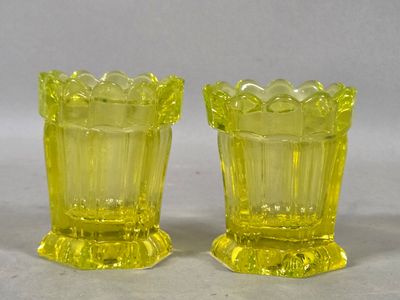 pair of yellow glass vases sitting on top of a white surface