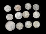 six different types of silver coins on a black background