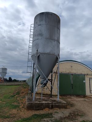 a large metal silo sitting in the middle of a field
