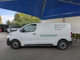 a white van parked under a blue umbrella in a parking lot
