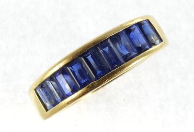 a close up of a gold ring with blue sapphire stones
