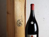 une bouteille de vin posée sur une table à côté d'une caisse en bois