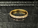 gros plan d'une bague en or sur une surface noire