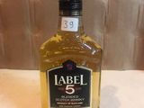 a bottle of alcohol sitting on a table next to a wall